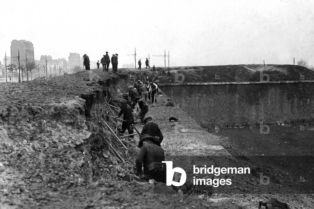 The workmen of the town of Paris demolish, with blows of pickaxes, the fortifications of the gate of Clignancourt, in May 1919