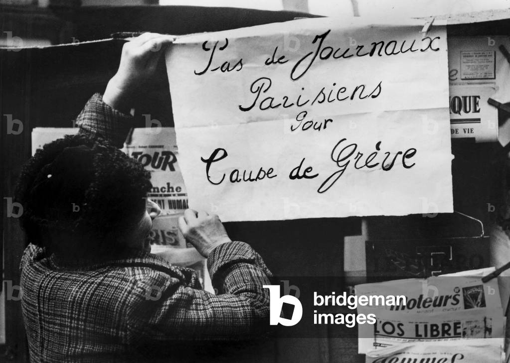 Outside a kiosk, the newsvendor display a sign indicating that there is no parisian papers because of strike, 1947