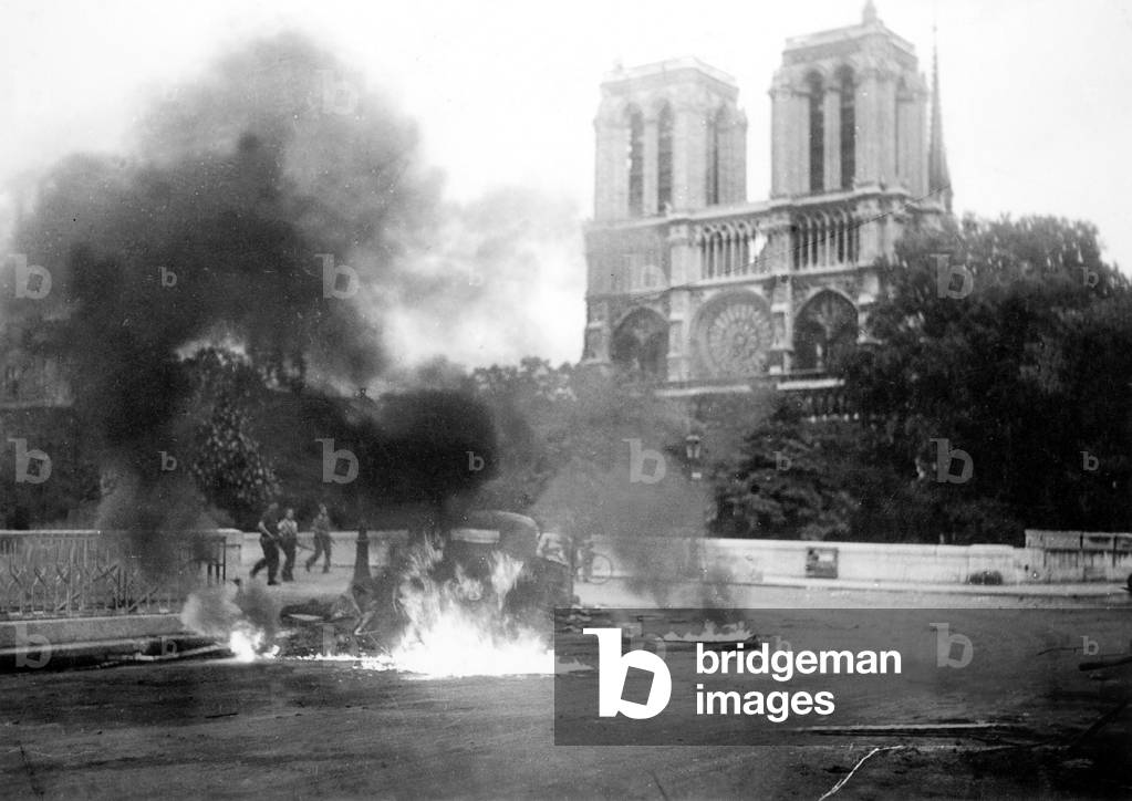 car burning in front of Notre Dame cathedral before the Liberation of Paris probably the 23th or 24th august 1944