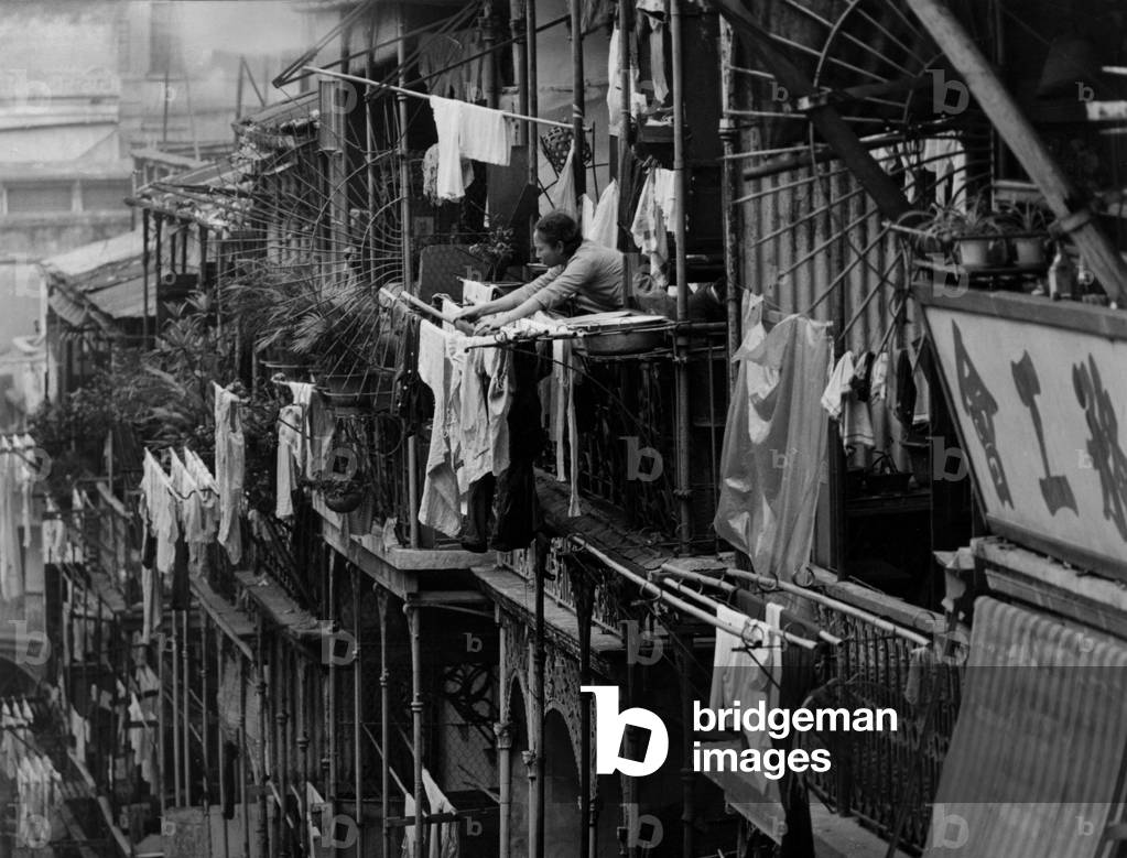 Hong-Kong : woman hanging out washing on her balcony, 50's