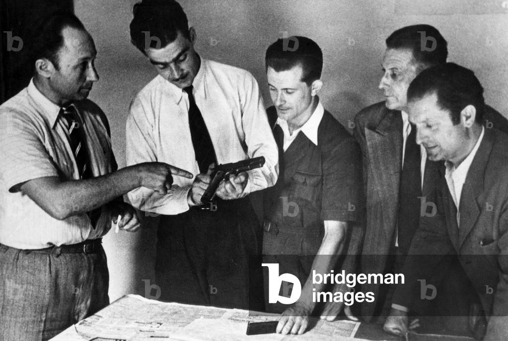 The SIMAPI brigade inspectors after the arrest of Jo Attia, his real name Joseph Brahim Attia, a gangster, examine the colt he wore -