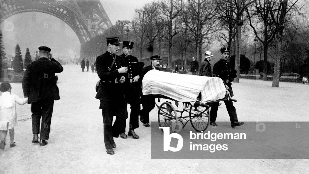 Policemen carrying the body of the inventor of a new type of parachute who wanted to test it from top of Eiffel Tower in Paris around 1923-1925