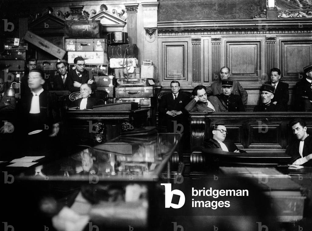 Trial of doctor Marcel Petiot (serial killer) march 1946 : Marcel Petiot boring in the dock, in the background : the cases and trunks where he put the valuables he stole his victims). In front of the box : his lawyer Rene Floriot