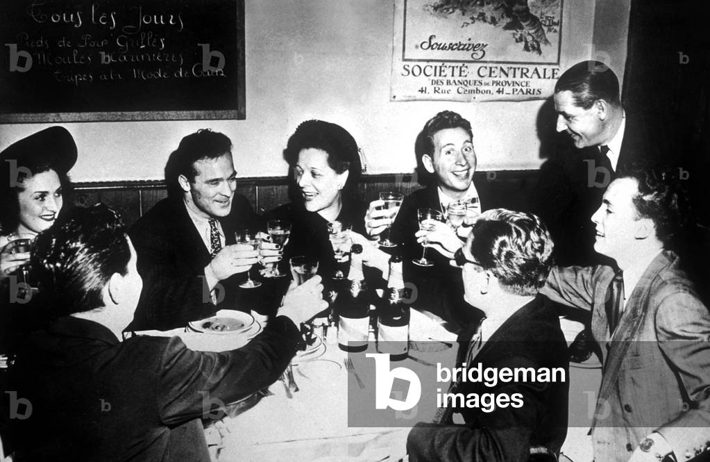 Marcel Cerdan at restaurant Le Bistrot in Paris with Mrs Jo Longman, Mrs Maud O'Connor Janet , harles Trenet, Robert Allembert , Jacques Pills, Jo Longman et Harris Seguela c. 1948
