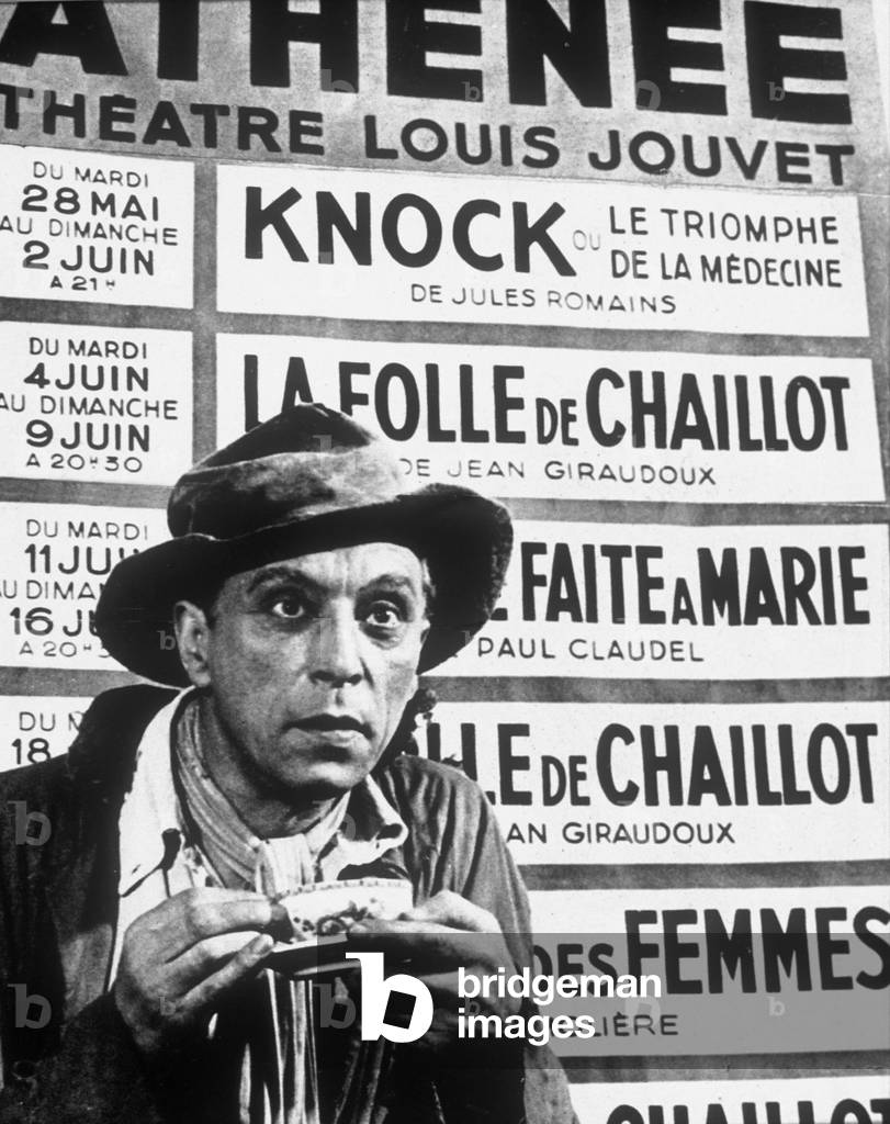 Louis Jouvet (1887-1951) French comedian in front of poster of his theatre in Paris just before his death, 1951