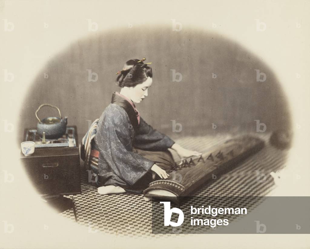 Woman playing a koto (hand-coloured b/w photo)