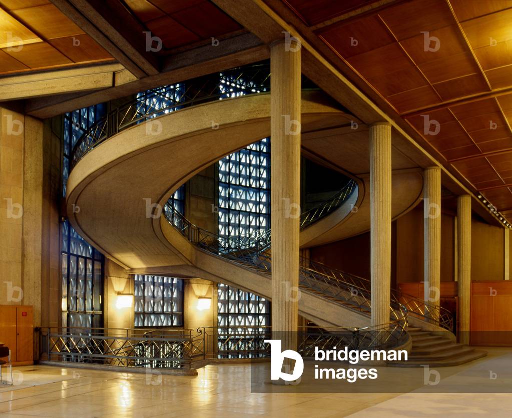 The Economic and Social Council, 1 avenue d'Iena in Paris 75016. Construction 1937-1939, architects Auguste (1874-1954) and Gustave (1876-1952) Perret. Originally, the Museum of Public Works was to be created for the 1937 Universal Exhibition on Chaillot Hill. In fact, its construction did not begin until January 1937. In 1939, the first rooms of the museum and the conference room were inaugurated. The museum will suffer delays due to the Second World War. This anthem to concrete has been home since 1959 to the Economic and Social Council, established by the 1958 Constitution promulgated by General de Gaulle. Interior architect Pierre Paulin signs the furniture of the hypostyle room. And Martial Raysse carries out the mosaics in the conference room.