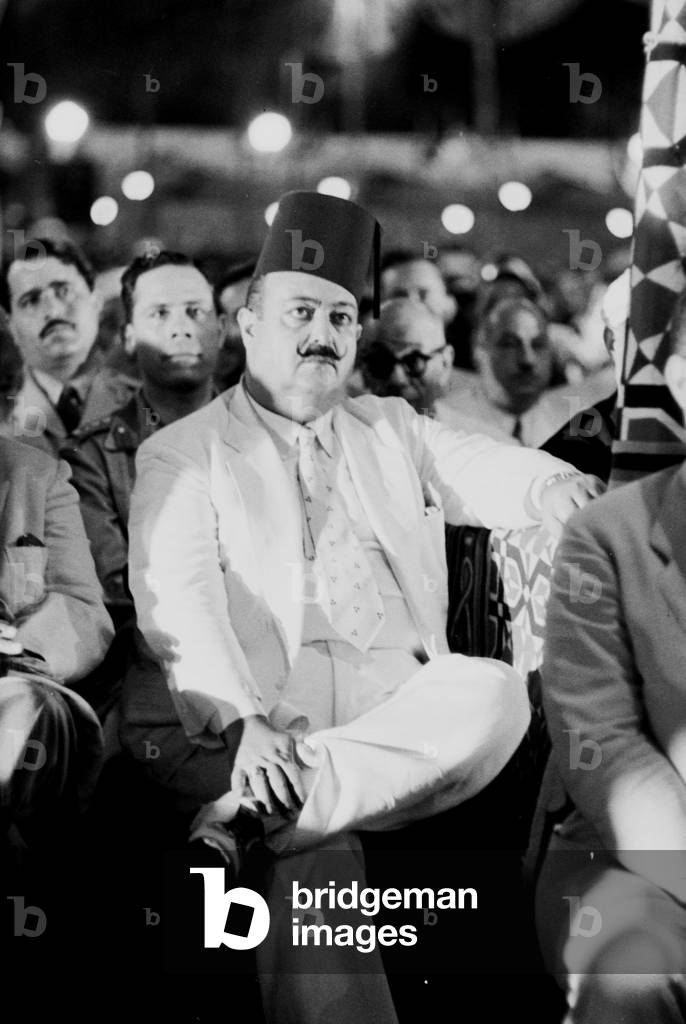 Head of the Lebanese delegation listening to Egyptian president Gamal Abdel Nasser's speech at the rally to celebrate the withdrawal of British troops from the Suez Canal Zone, Egypt, 1956 (b/w photo)
