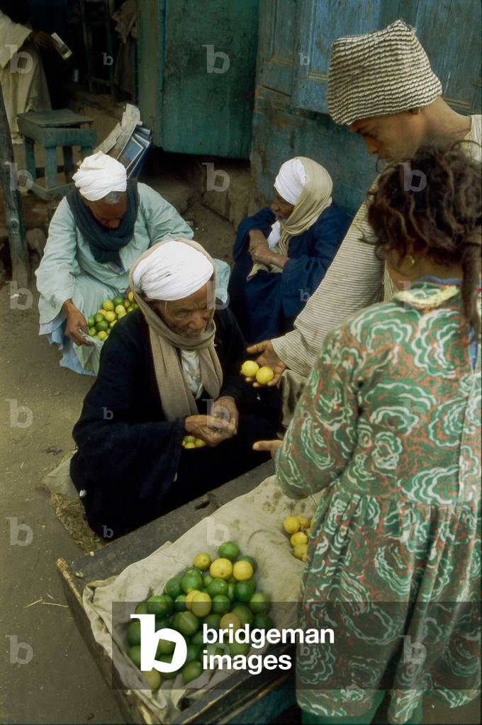 Merchant of green and yellow lemons in Aswan, Egypt.