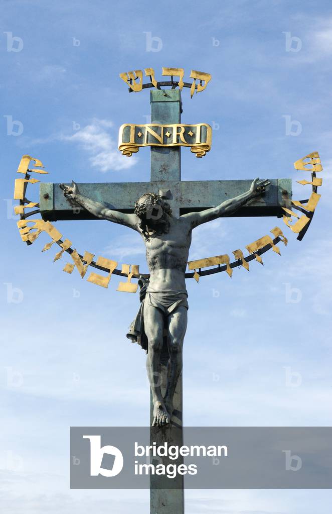 The Crucifixion. 17th century. Sculpture originally made in 1629 by H. Hillger based upon a design by W. E. Brohn. Bronze. The golden Hebrew text on the crucifix was added in 1696. Decorates the Charles Bridge. Prague. Czech Republic.