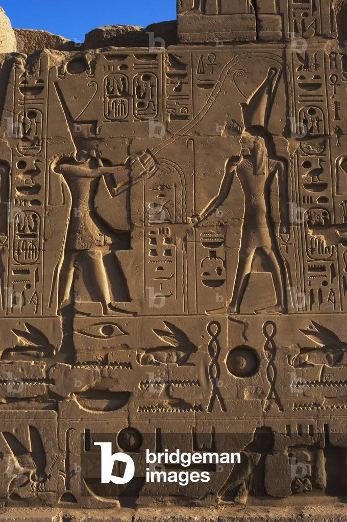Egyptian Art. Karnak. The Pharaoh Ramesses II making an offering or libation before god Atum. Relief.