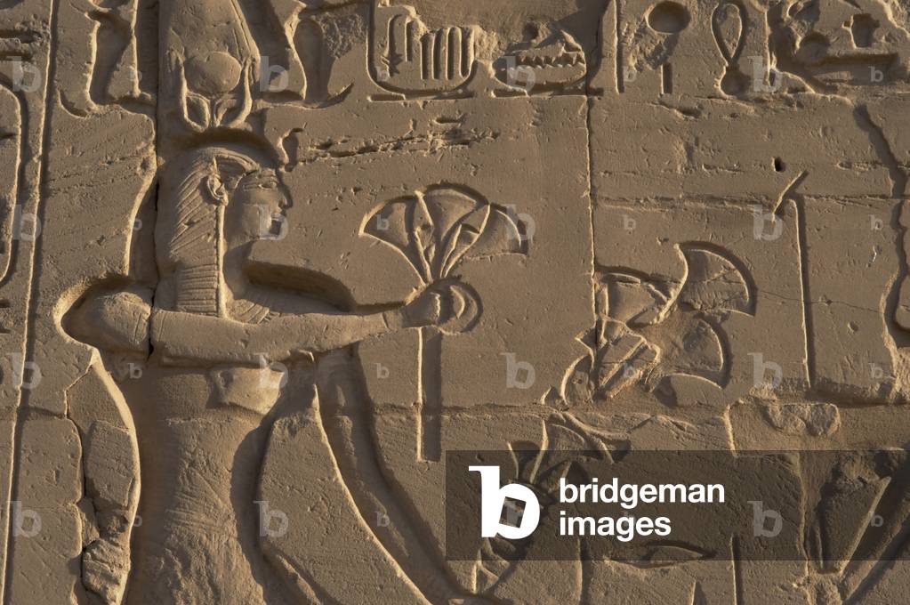 Egyptian Art. Karnak. A pharaoh making an offering of flowers of papyrus to the gods. Relief.