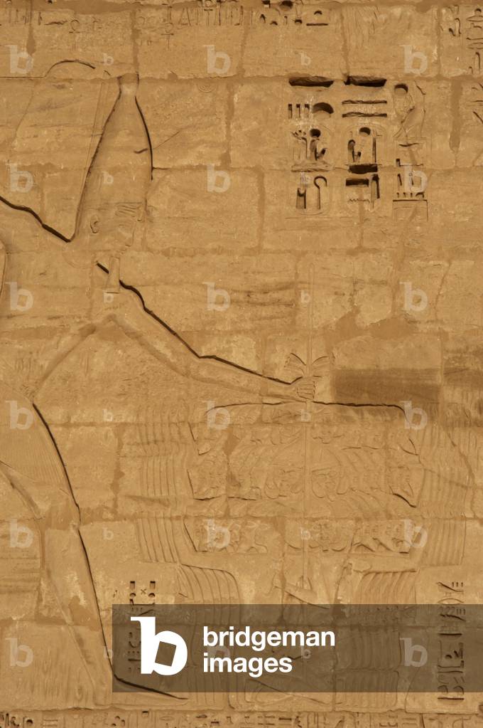 Temple of Ramses III. Relief depicting Ramses III capturing his enemies before Amun. Detail of the pharaoh. Medinet-Habu. Egypt.