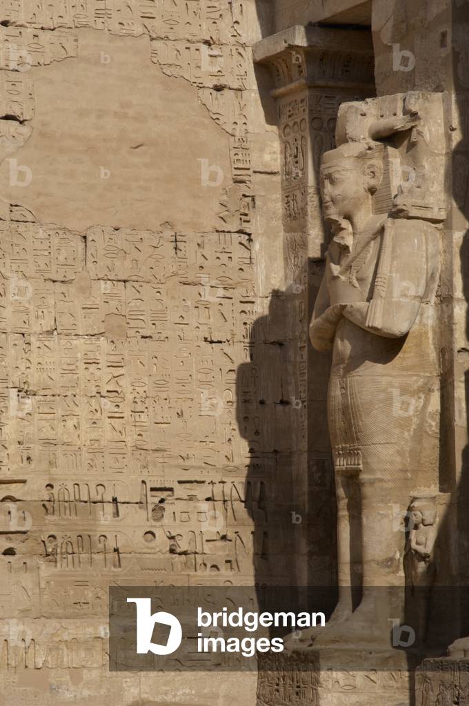 Temple of Ramses III. Great colossal statues of Ramses III deified as Osiris, attached to pillars. Egypt.