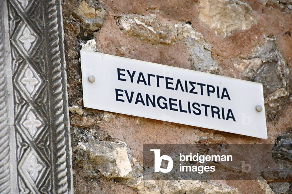 Bilingual poster on the wall of the Church of Evangelistria. Mystras. Greece.