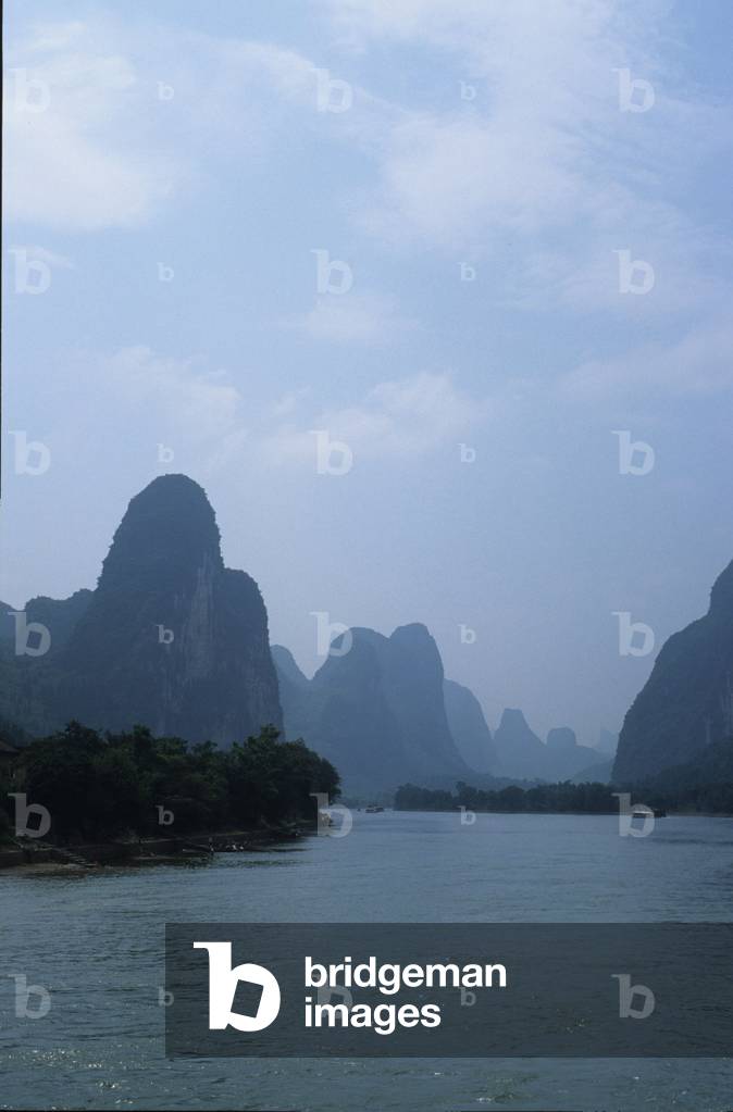 Landscape in China: boat between karst rocks bordering the Li River near Guilin.