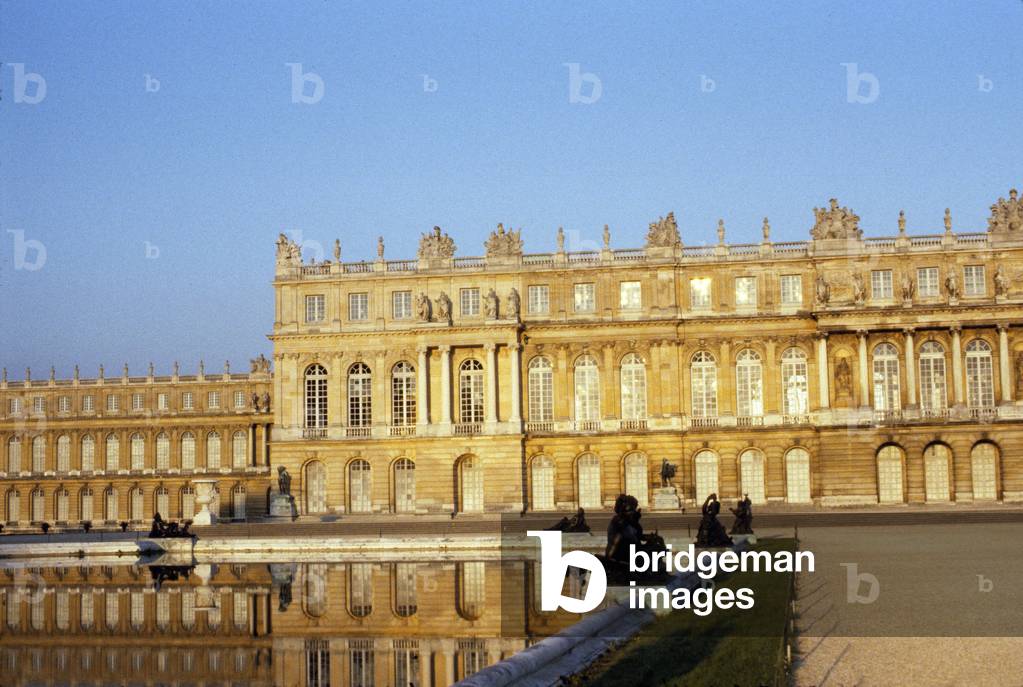 Facade of the castle of Versailles reflected in the water beds, bronze statues melted by the Keller brothers. Yvelines (78).