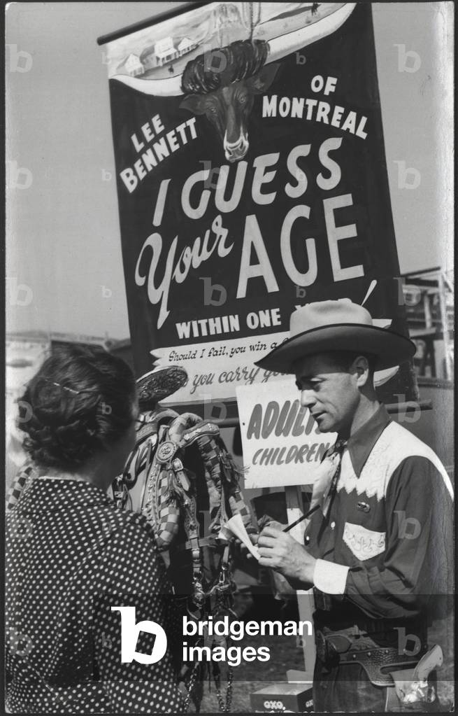 Lee Bennett guessing a woman's age at his 'I Guess Your Age' attraction at the Hoppings Fair, UK, c.1940s (b/w photo)