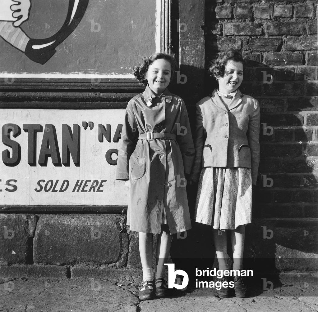 Two girls outside a shop, Sycamore Street, Newcastle upon Tyne, 1957 (b/w photo)
