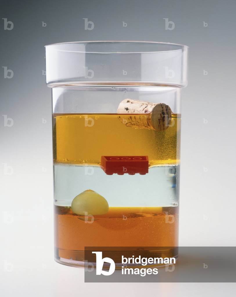 Image of Glas, das Flüssigkeitsschichten unterschiedlicher Dichte enthält, darunter Sirup, Wasser, Öl