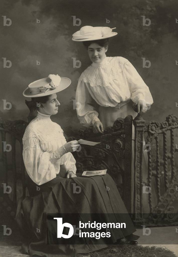 Bild von Fotografie "Zwei junge Frauen betrachten eine Fotografie" von Unknown photographer, b/w