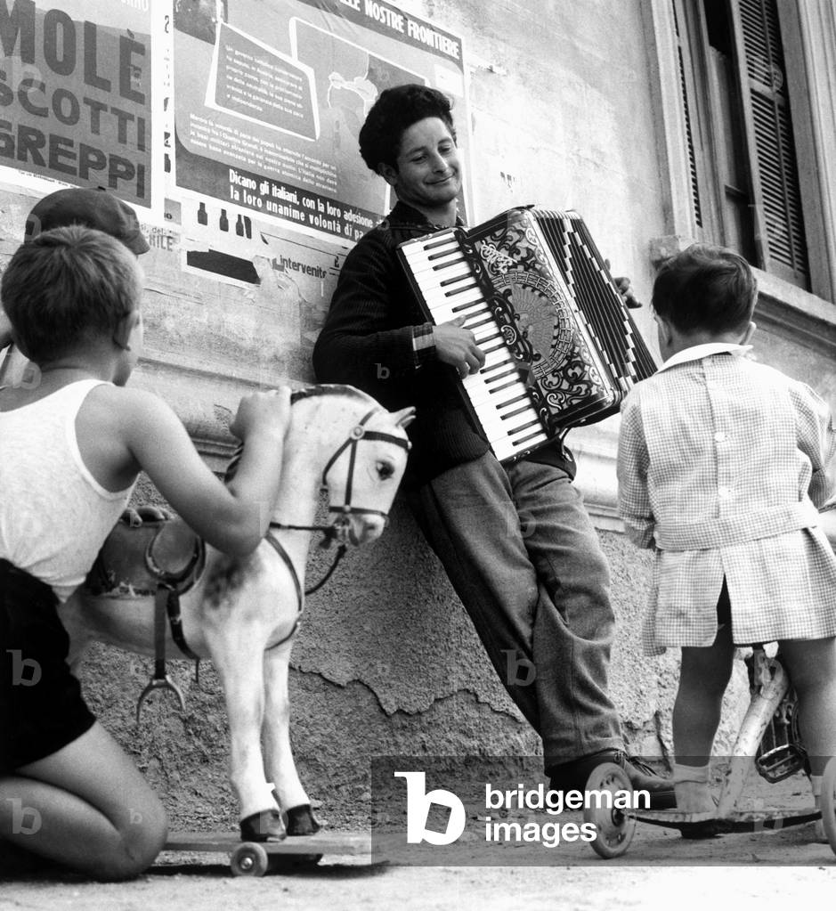 Street Musician in Milan, 1959 (b/w photo)