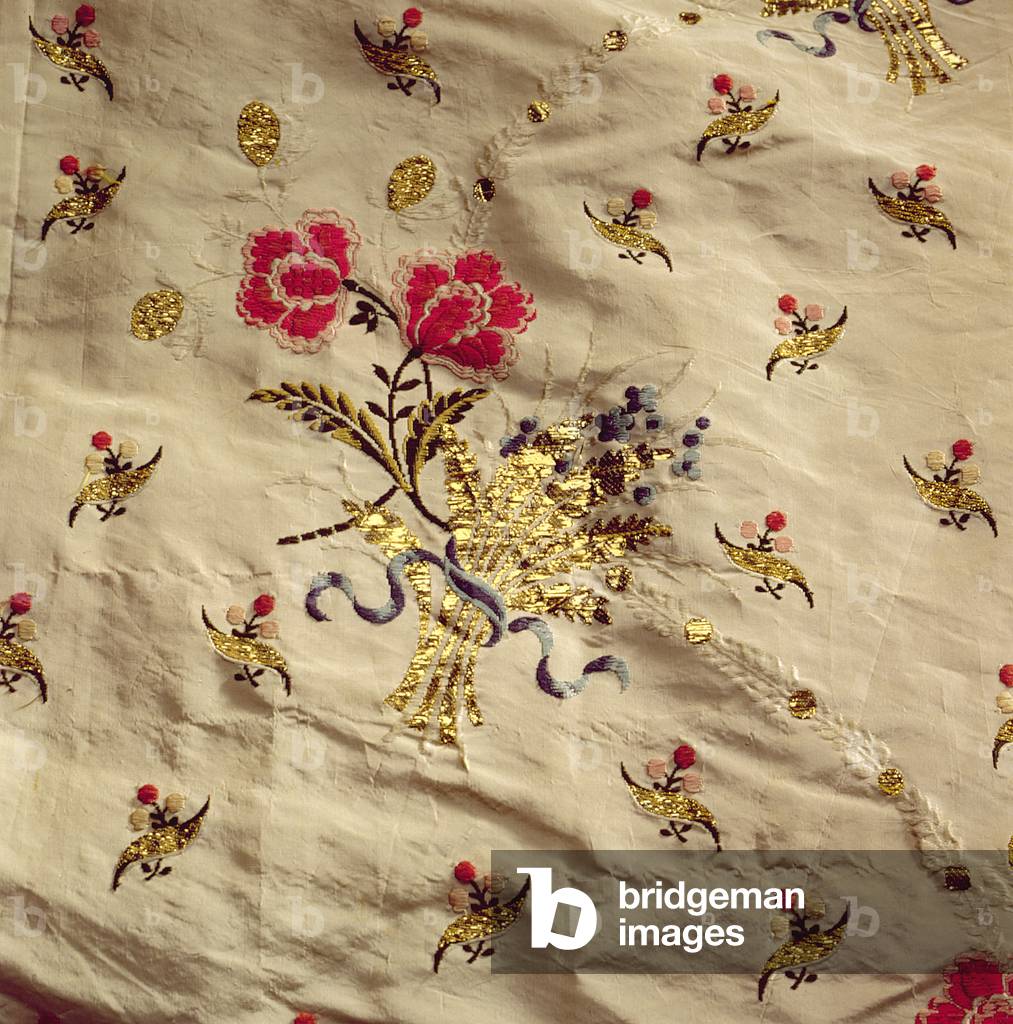 Detail of piece of material with gilt stitching of flowers and leaves on cream silk (embroidered silk)