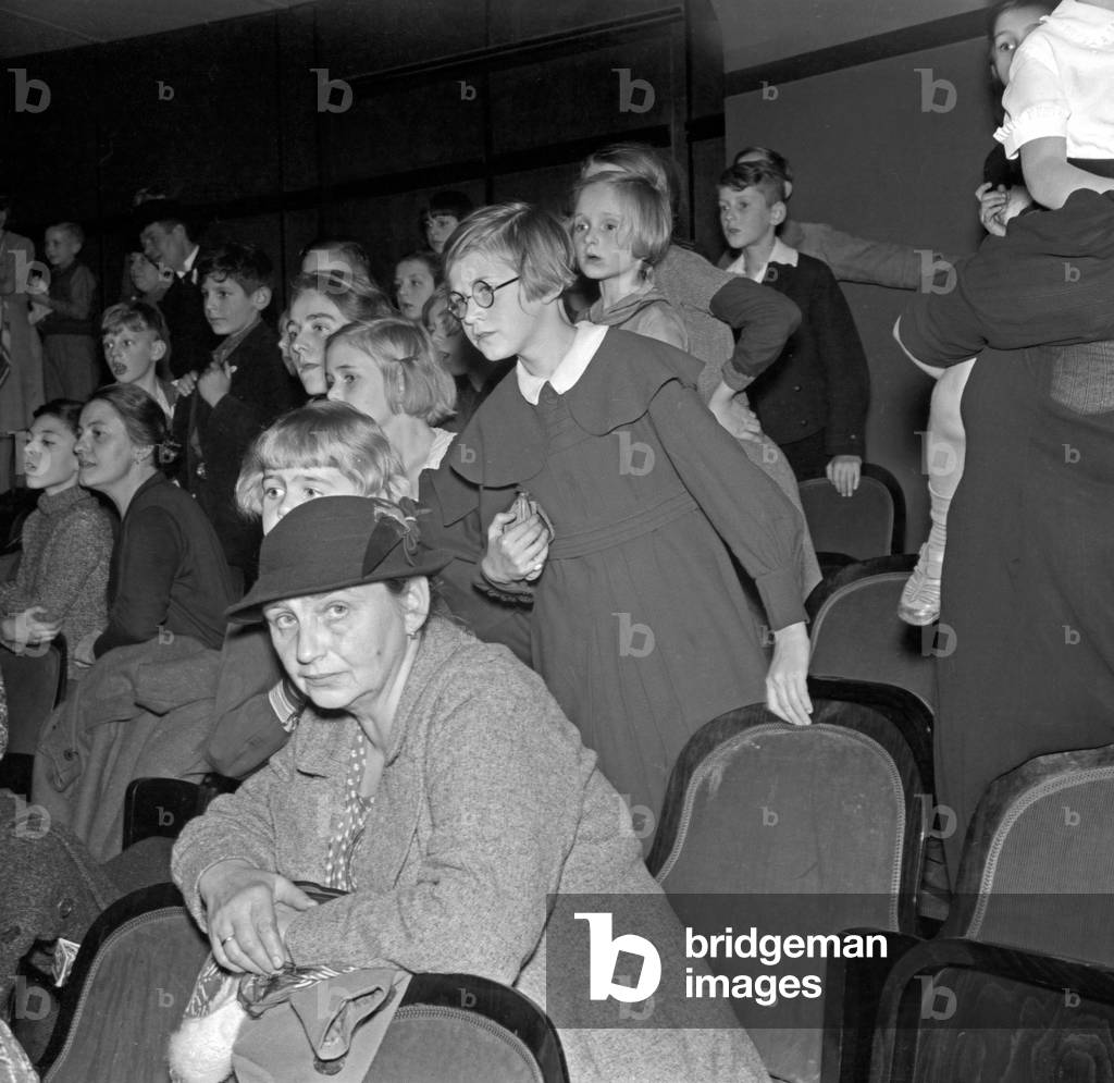 The adience at the children's show at the Rose theatre at Berlin, Germany 1930s (b/w photo)