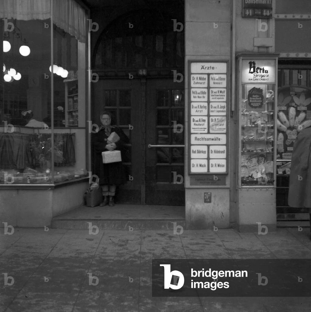 A woman standing in the entrance of a house at Gaensemarkt in Hamburg, 1954