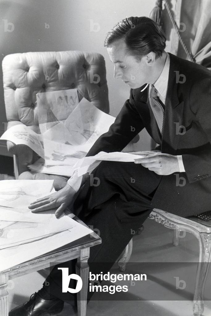 The fashion designer Heinz Schulze-Bibernell looking at his design sketches, Germany ca.1939 (b/w photo)