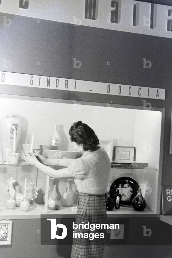 A visitor of the Leipziger Frühjahrsmesse in front of a stand of the porcelain factory Richard Ginori, Germany 1941 (b/w photo)