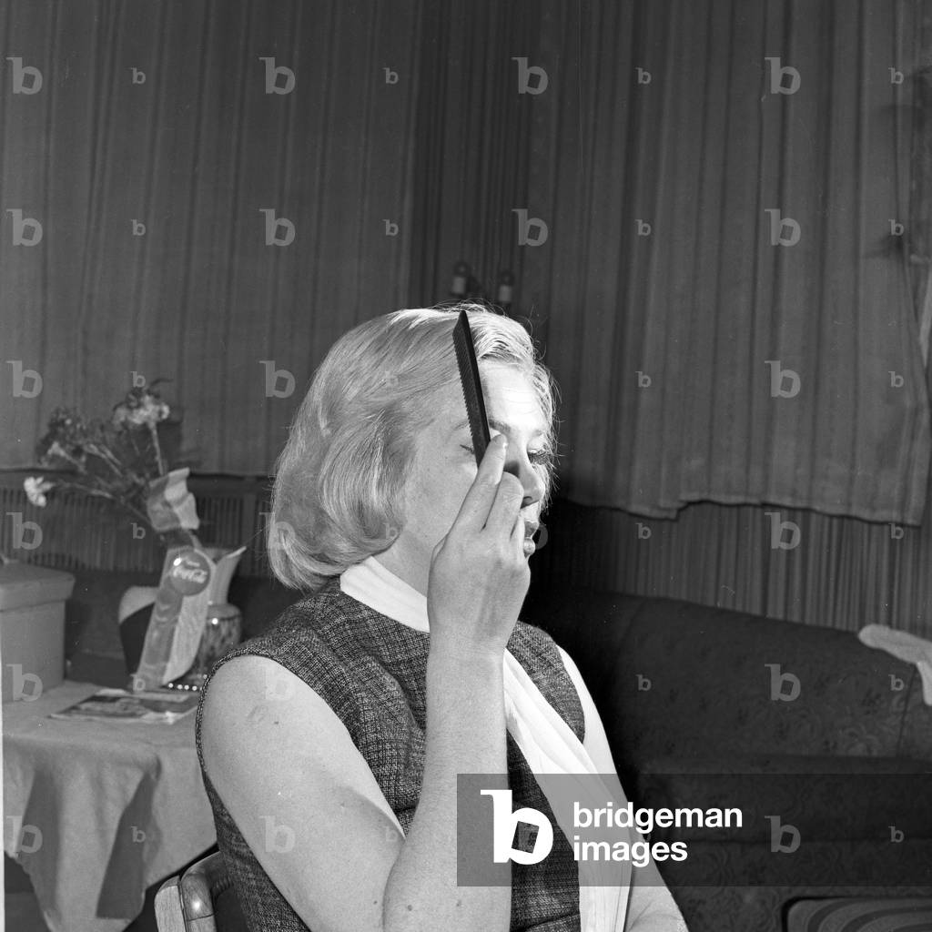German actress, chanson singer and author Hildegard Knef combing her hair at Hamburg, Germany 1960s
