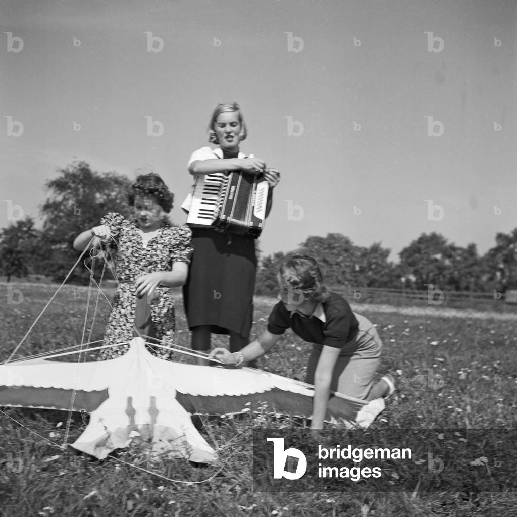 Three women playing music with an accordion, Germany 1930s (b/w photo)
