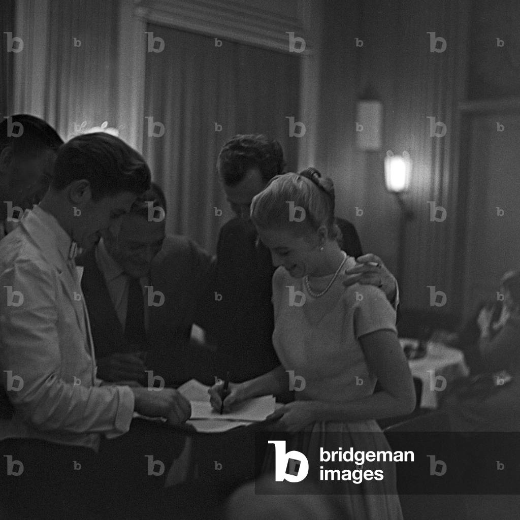 American actor and chansonnier Eddie Constantine and Danish singer duo Nina and Frederik sigining autographs for the waiters of a restaurant at Hamburg, Germany 1950s