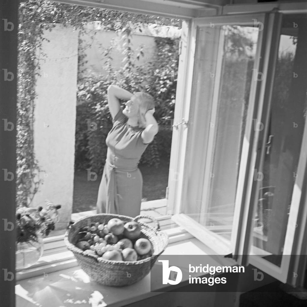 A young woman, seen through a window, Germany 1930s (b/w photo)