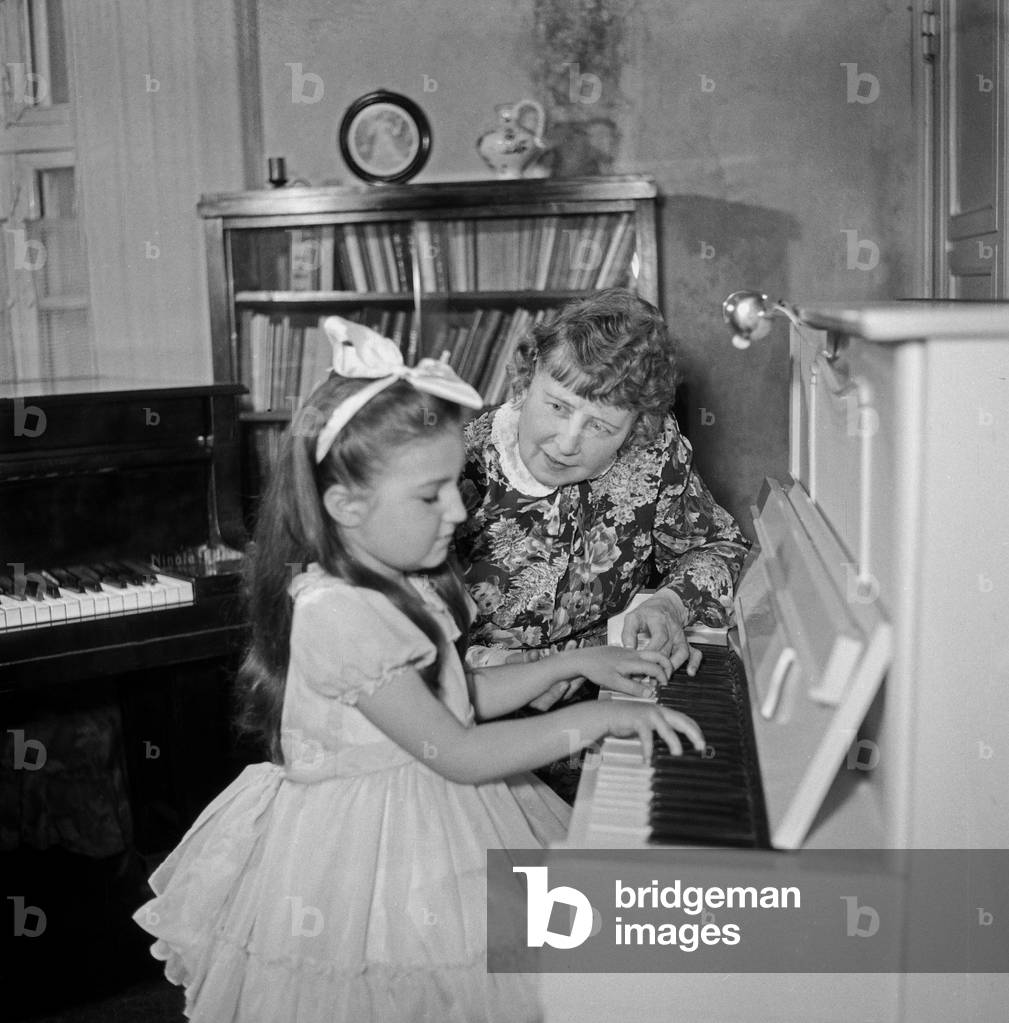 A little girl playing a piano