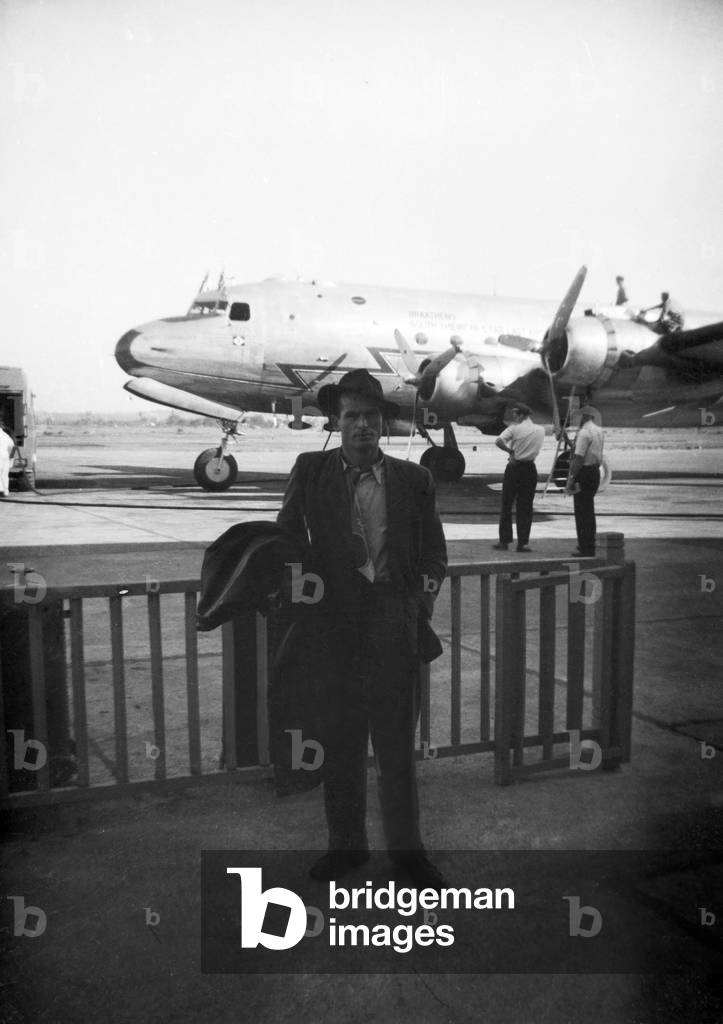 A young man in front of a plane at the airport of Las Vegas, 1954