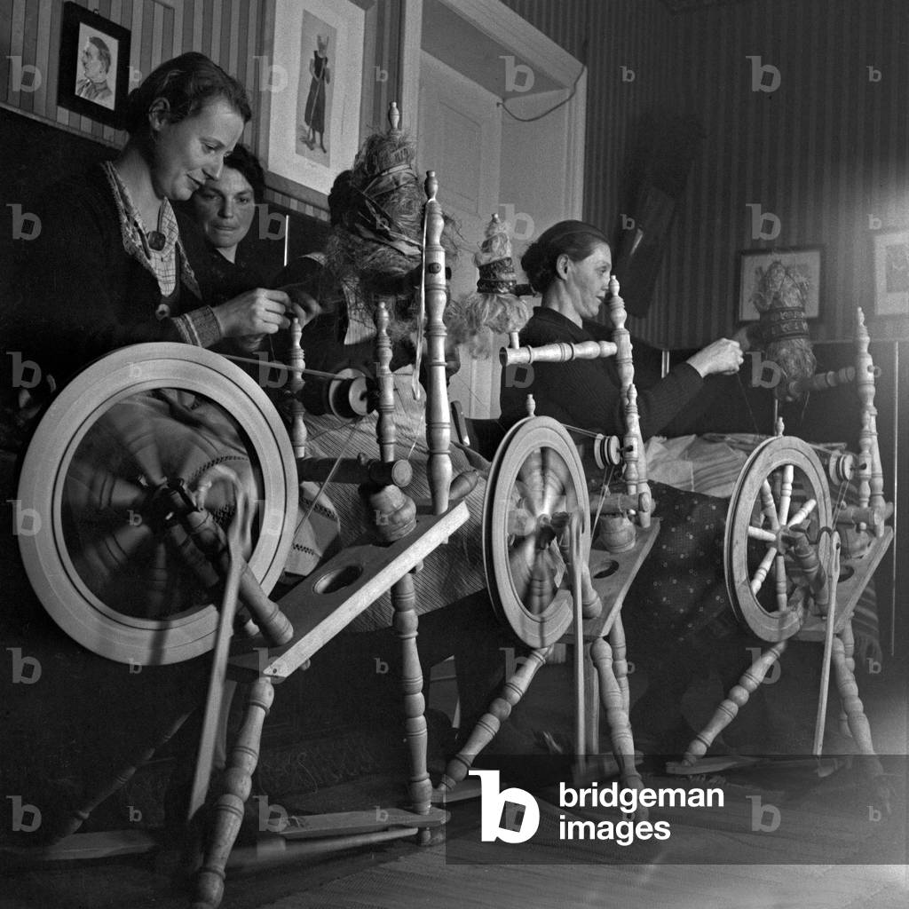 Three women with their spinning wheels at the Sommerfeld school for weaving, Germany 1930s