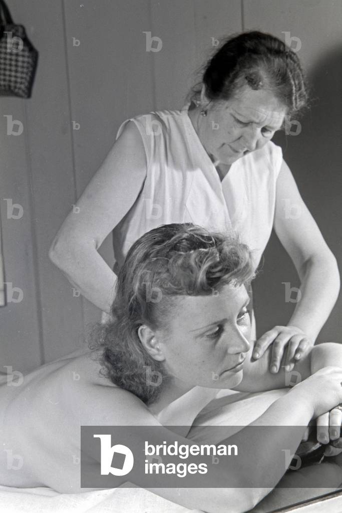 A young woman gets a massage at Admiralsbad bath in Berlin, Germany 1930s (b/w photo)