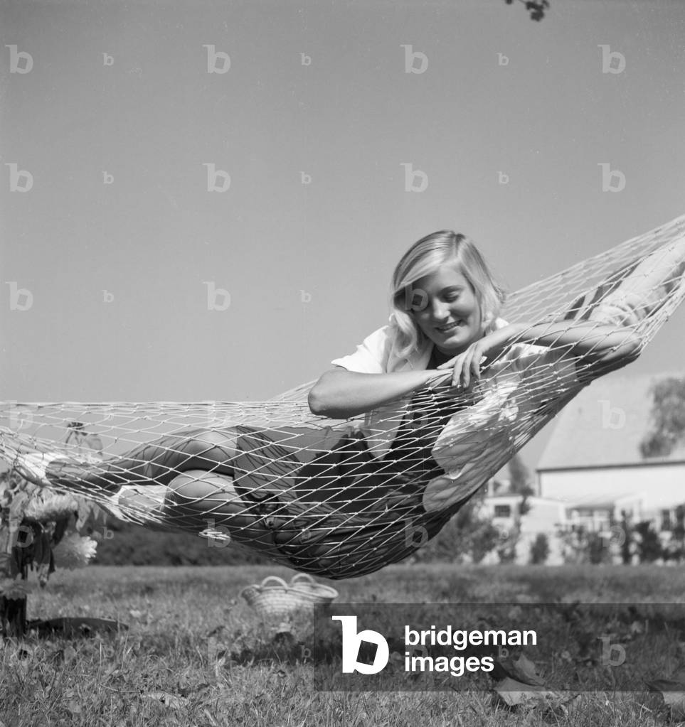A young woman in the garden in summertime, Germany 1930s (b/w photo)