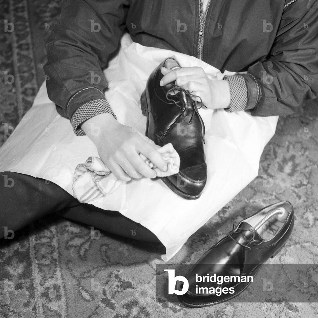 A young girl has cleaning her father's shoes, Germany 1955