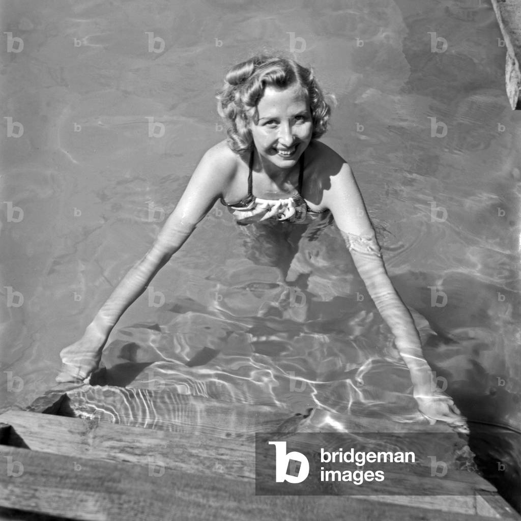 A young woman climbing off of a lake at Austria, 1930s (b/w photo)