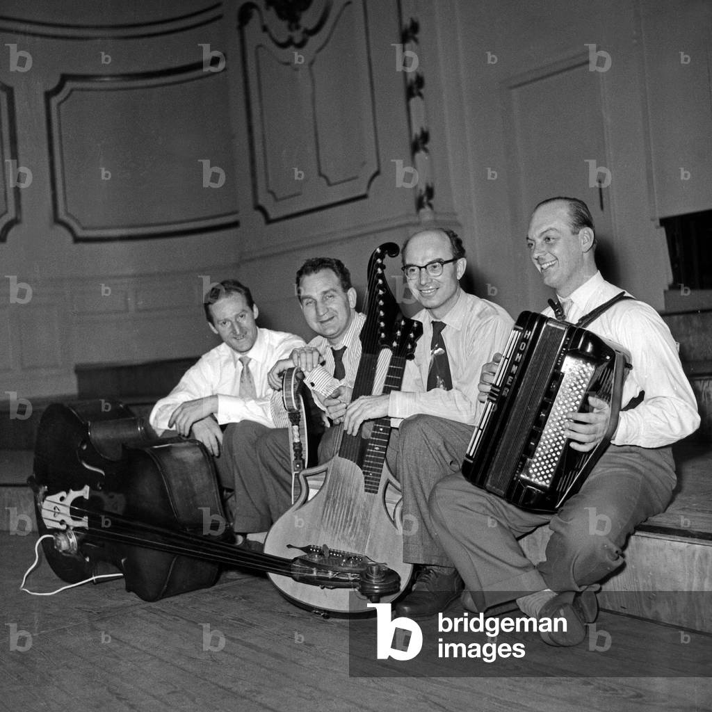 German composer and zither player Alfons Bauer with his instrument and boxing gloves accompanied by a small orchestra