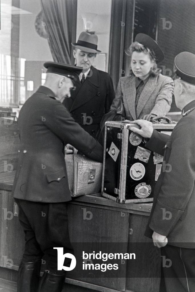 A female passenger with a customs officer at Berlin Tempelhof airport, Germany 1930s (b/w photo)