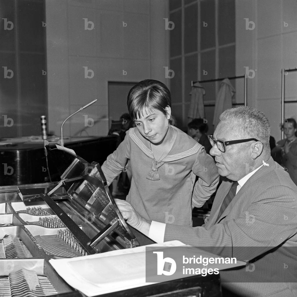 A man and a little gril at the piano in the 