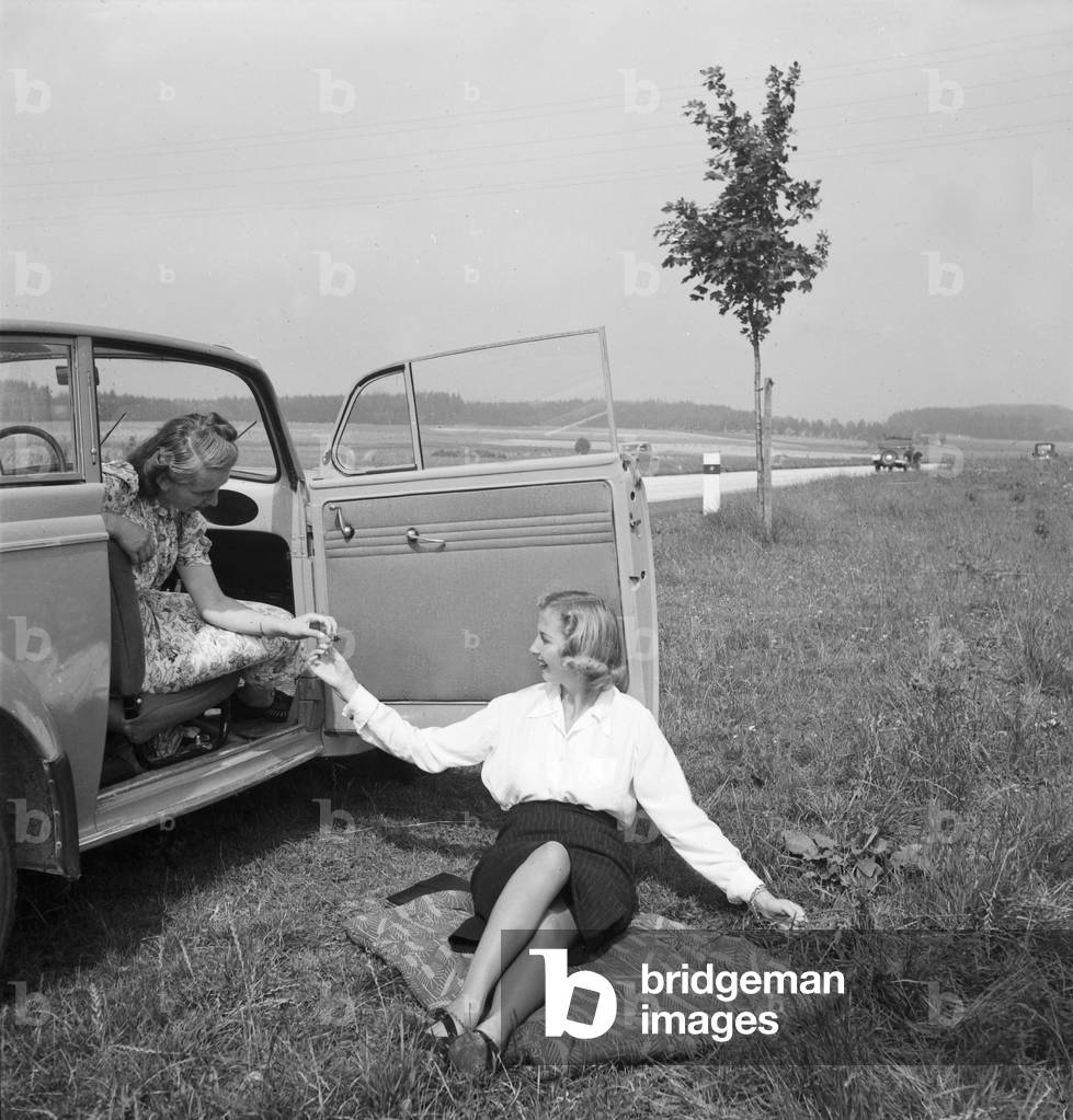 Two women having a break near a street in Austria, 1930s (b/w photo)