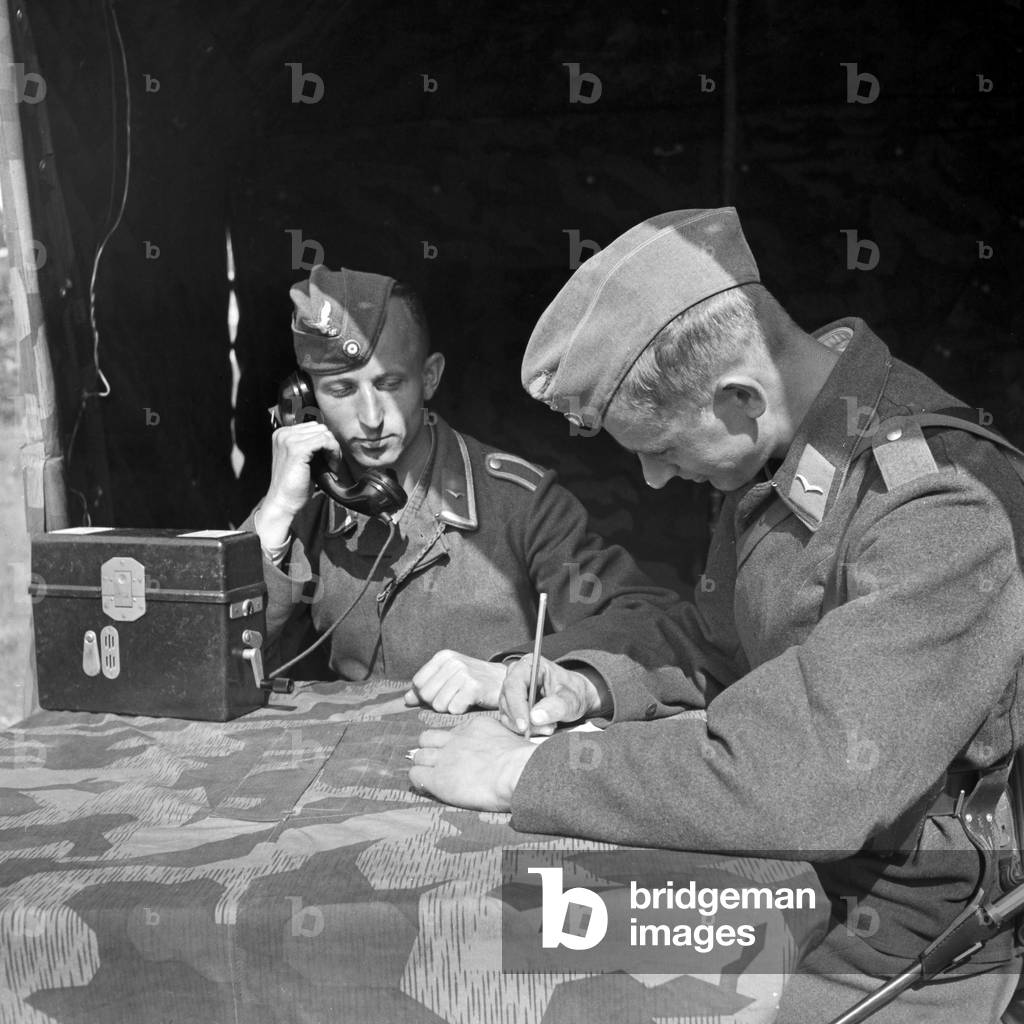Soldiers of the signal corps forwarding orders at a tent, Germany 1940s (b/w photo)