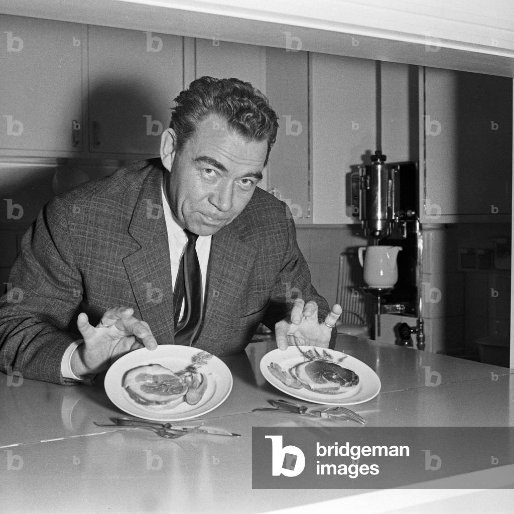 German show presenter and entertainer Peter Frankenfeld with to plates of bacon, Germany 1950s