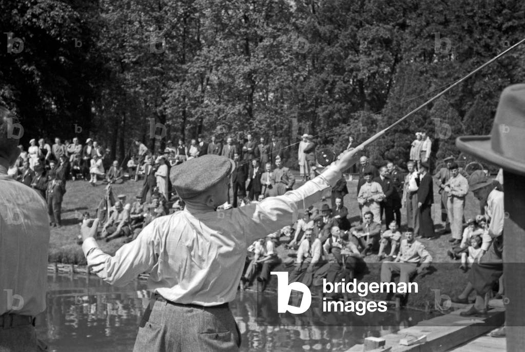 A man throwing his angling rod at an angling contest, Germany 1930s (b/w photo)