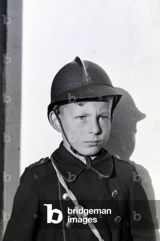 Portrait of a uniformed boy of the junior firefighters during a training, Germany 1930s (b/w photo)